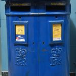Auf Guernsey sind die Postkästen blau, nicht rot, die lokale Post wird in den Schlitz mit der Aufschrift "Bailiwick" (Vogtei) geworfen